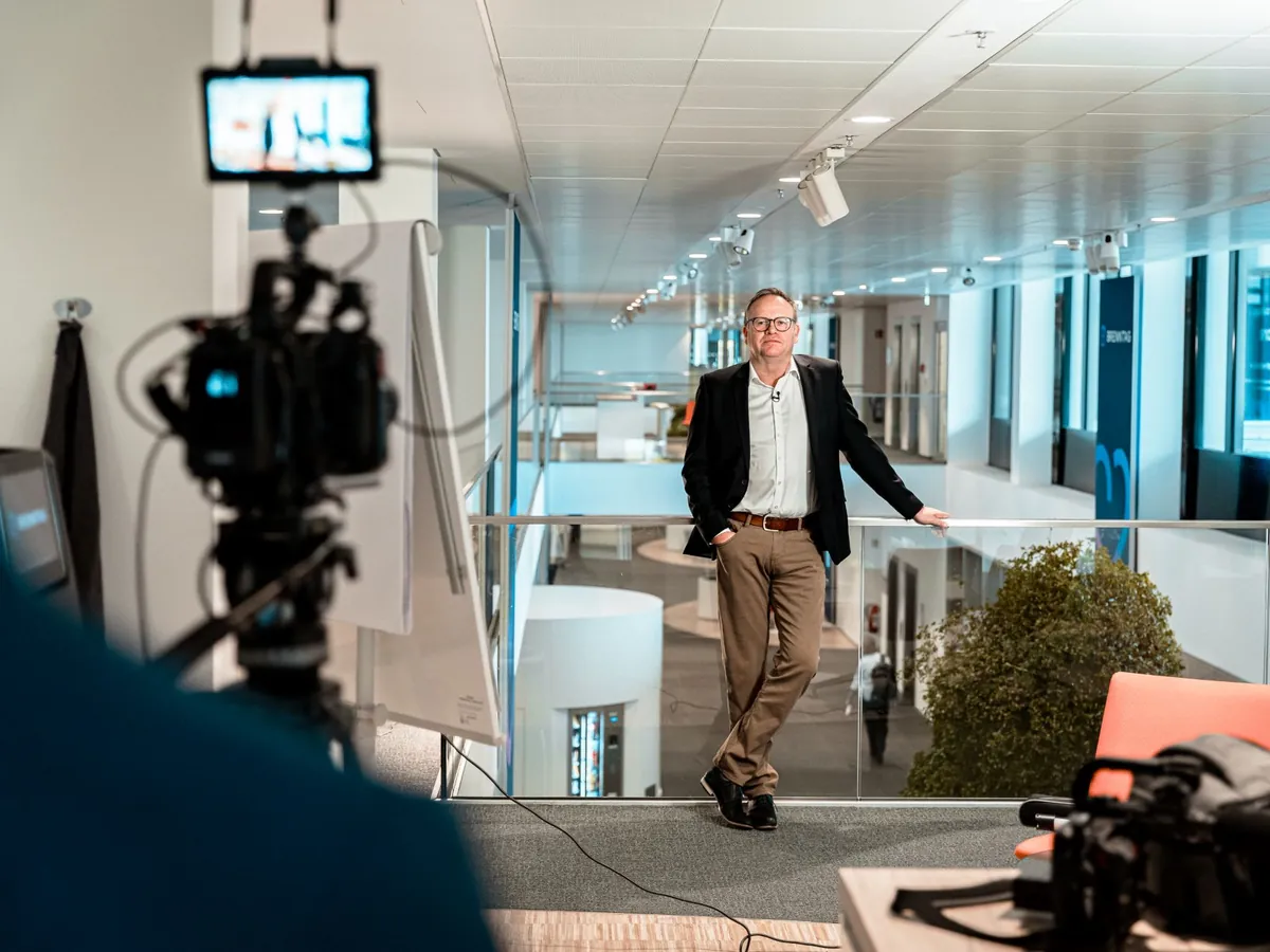 Kamera vor einem Interview auf der Galerie über dem Atrium, im Hintergrund ein Banner von Brenntag