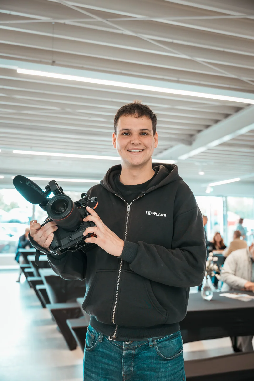 Mitglied des CreativCube-Teams mit Kamera beim Dreh im Autohaus