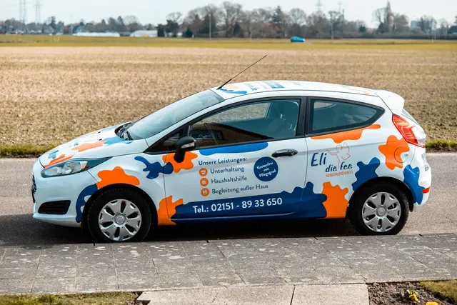 Dienstwagen von Eli die Fee mit bunter Beklebung am Feldrand