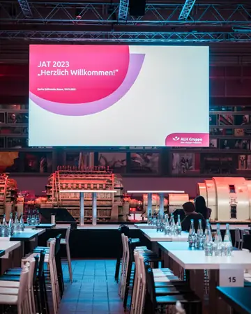 Festlich eingedeckte Grand Hall mit der Begrüßung zum Jahresauftakt 2023 auf der Leinwand