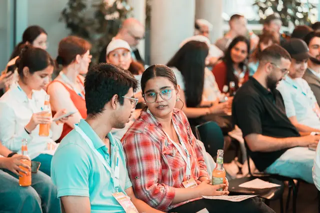 Teilnehmende lachen gemeinsam in der Startup-Lounge