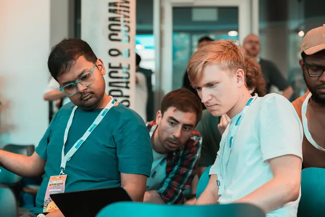 Teammitglieder arbeiten gemeinsam am Laptop