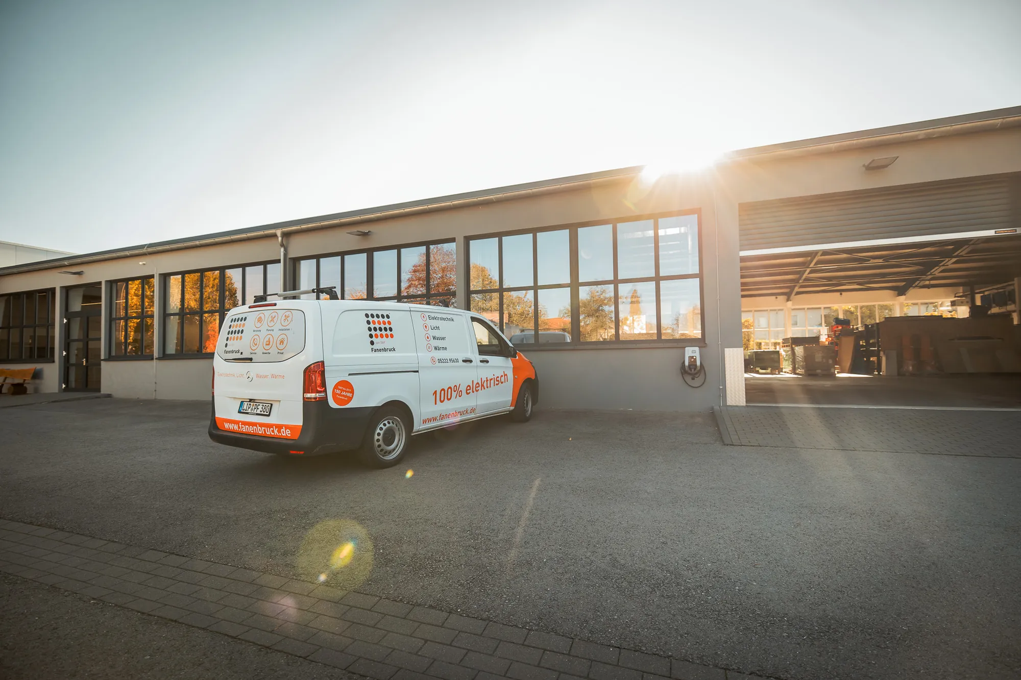 Firmensitz von Fanenbruck in Bad Salzuflen mit Werkstatt und Firmenwagen im Gegenlicht
