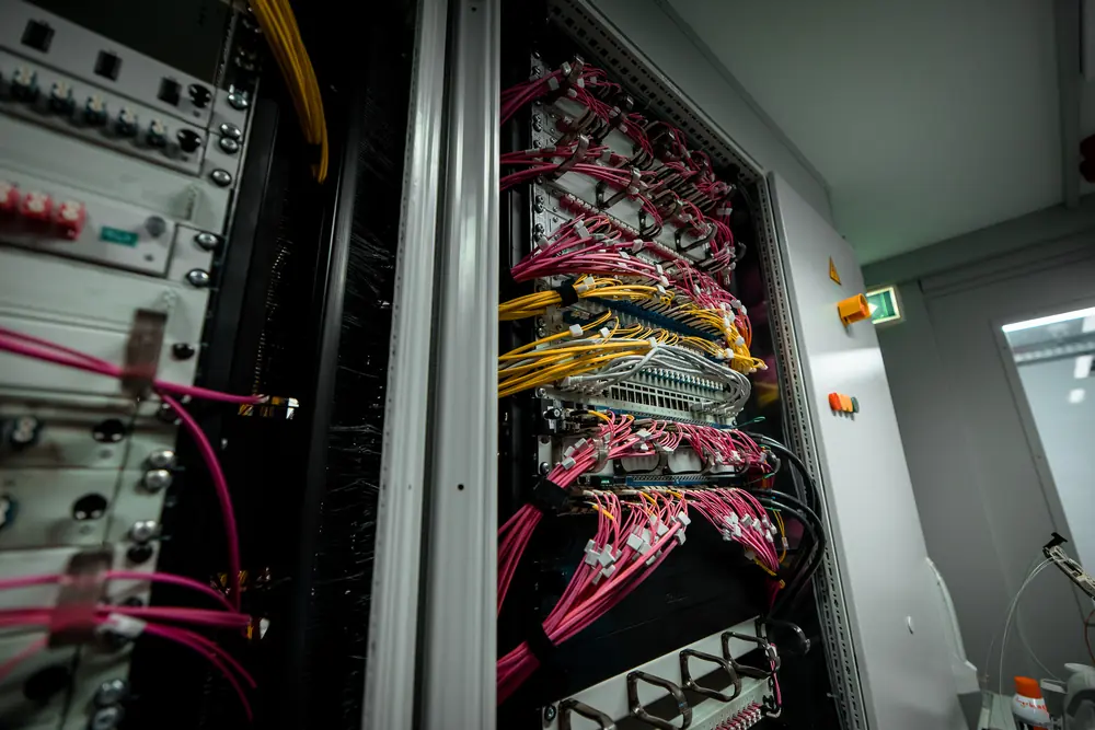 Netzwerkschrank mit sauber geführten pinken und gelben Patchkabeln