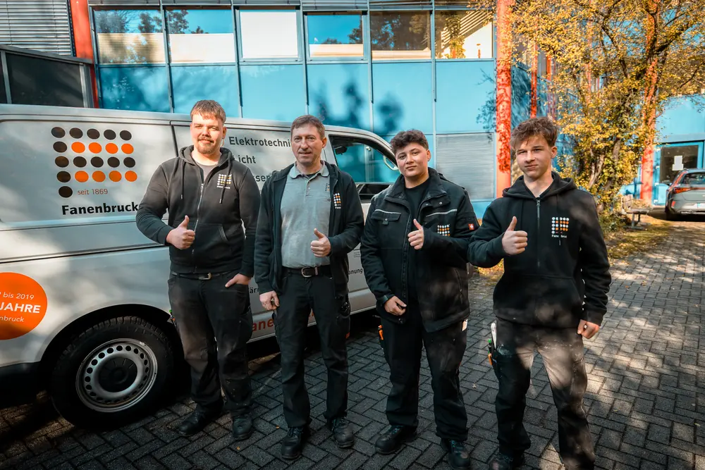Team von Fanenbruck vor einem Firmenwagen, die Daumen nach oben