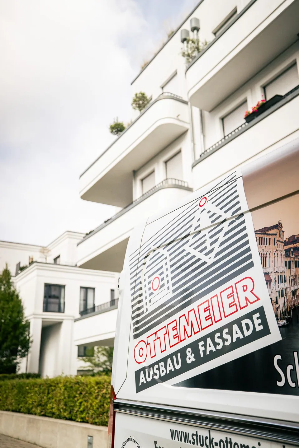 Transporter von Ottemeier Ausbau und Fassade vor einer Wohnanlage
