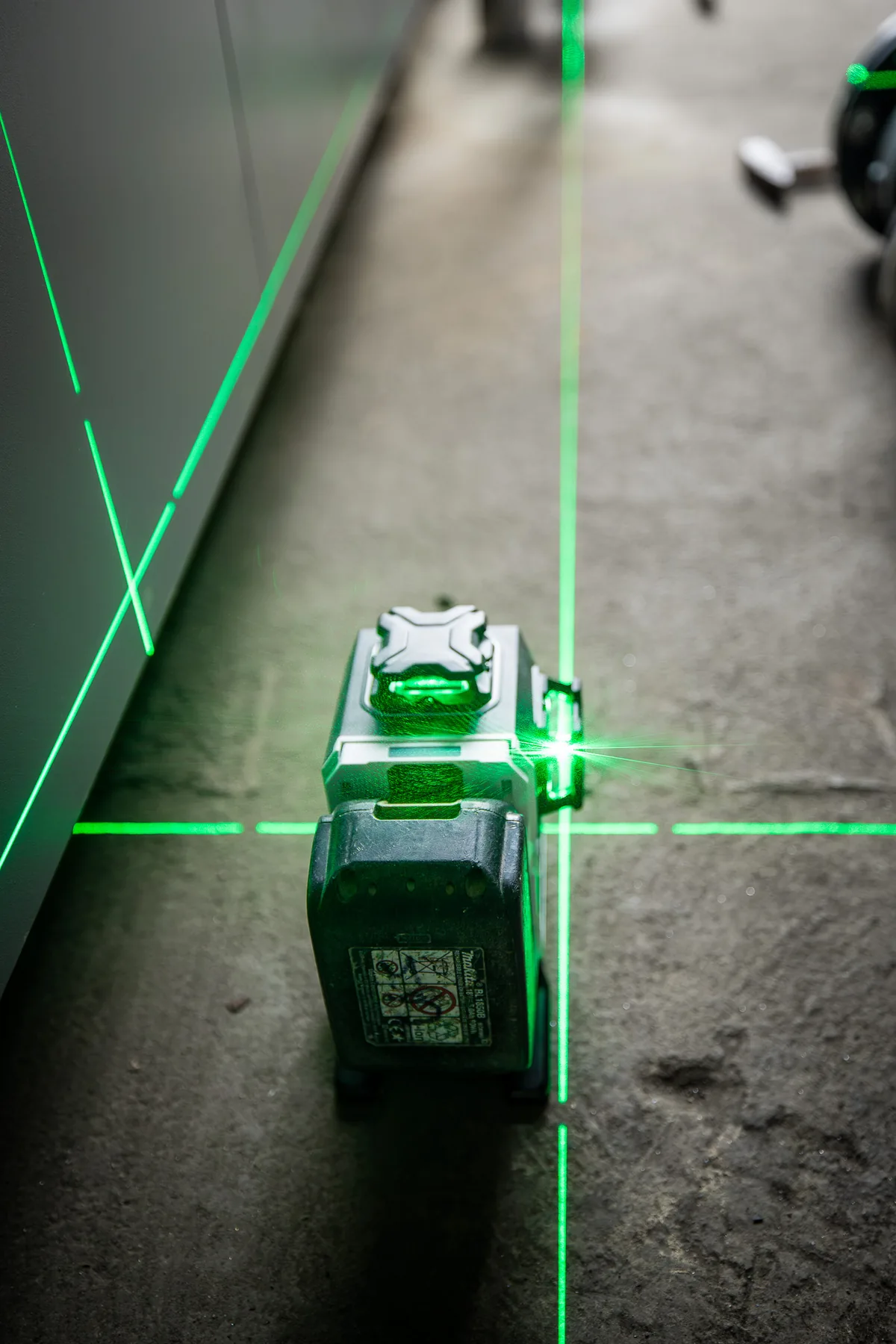 Grüner Linienlaser markiert die Leitungsführung im Rohbau
