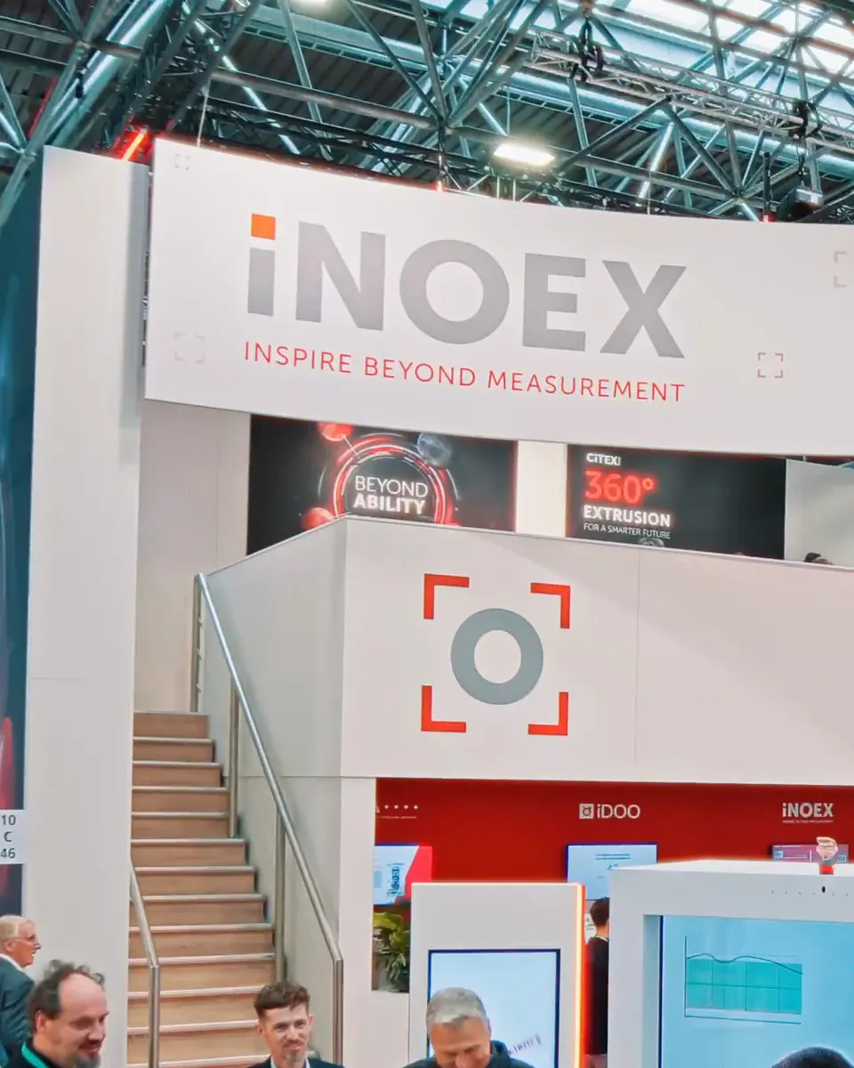 Messestand von iNOEX auf der K 2025 mit Treppe und dem Motto Beyond Ability
