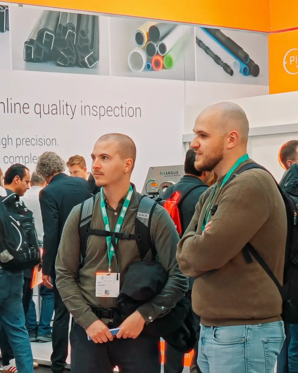 Fachbesucher vor der Wand zur Inline-Qualitätsprüfung am Stand von iNOEX