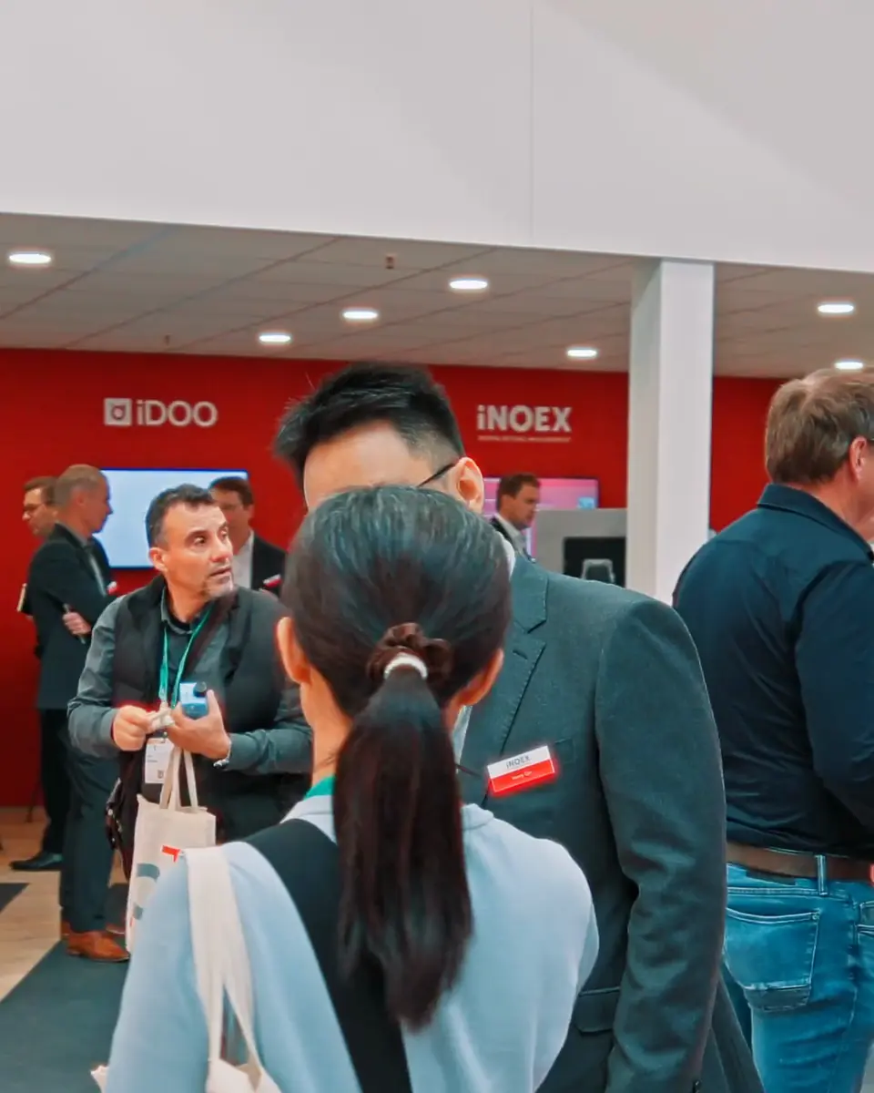 Internationale Besucher im Gespräch mit einem Mitarbeiter von iNOEX