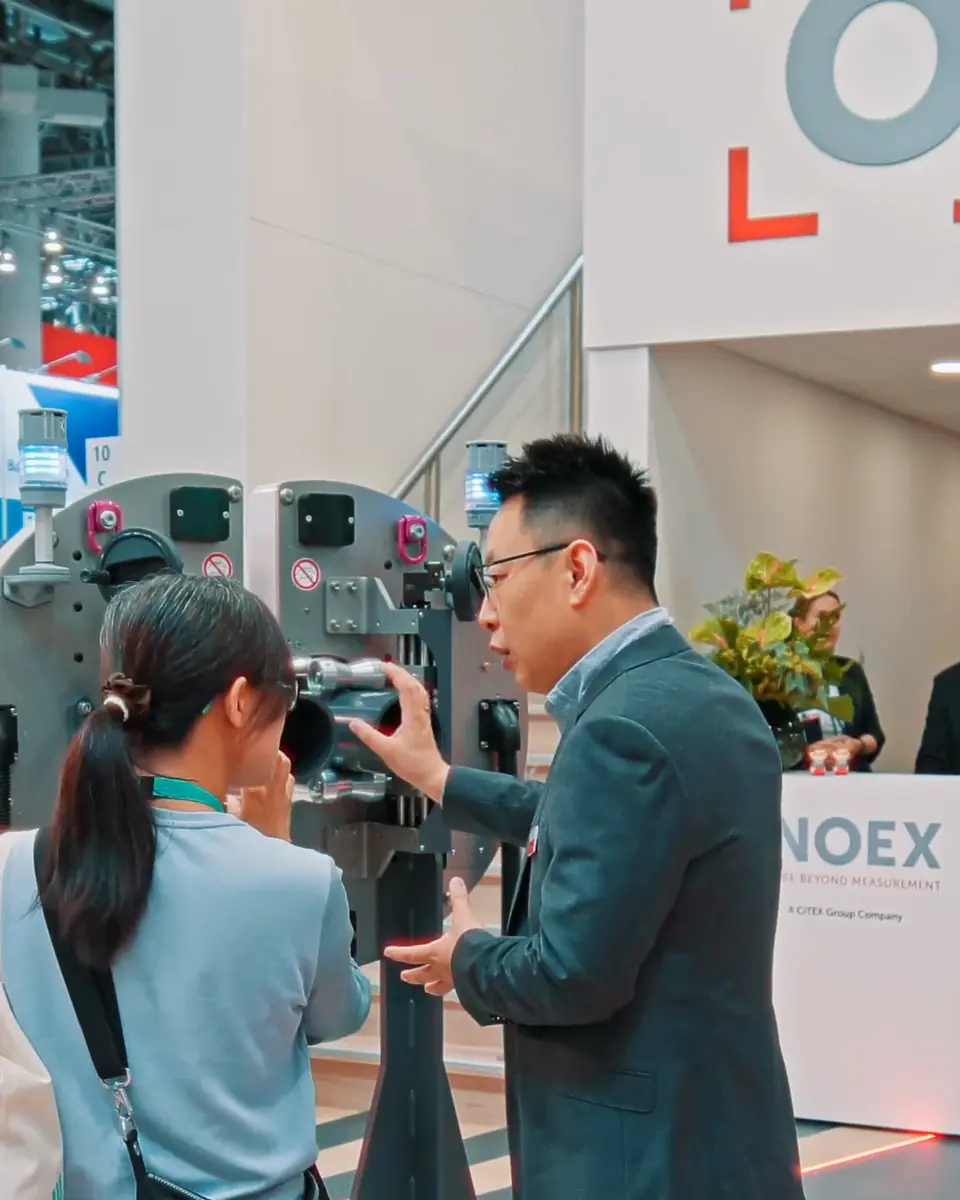 Besucherin und Mitarbeiter von iNOEX am Messsystem WARP auf der K 2025