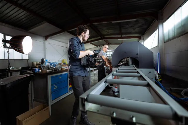 Dreh mit Gimbal und großer Leuchte an einer Maschine in der Halle