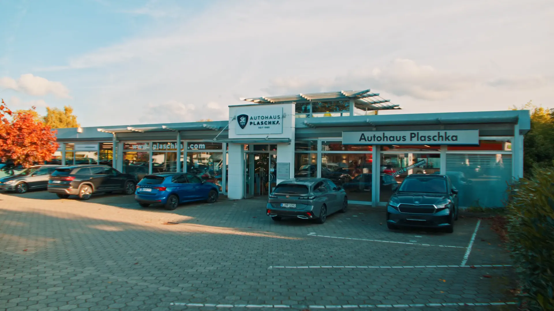 Das Autohaus Plaschka von außen mit Fahrzeugen auf dem Hof