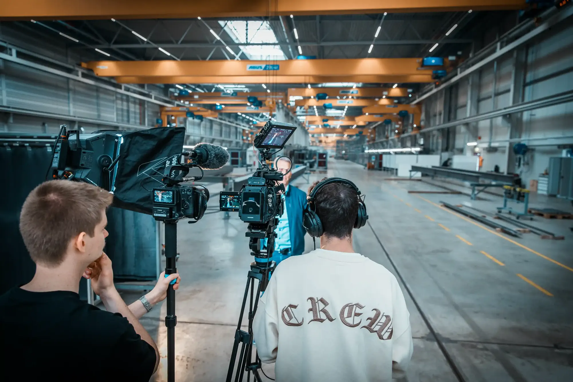 CreativCube-Crew mit Kamera auf dem Stativ bei einem Dreh in einer Industriehalle