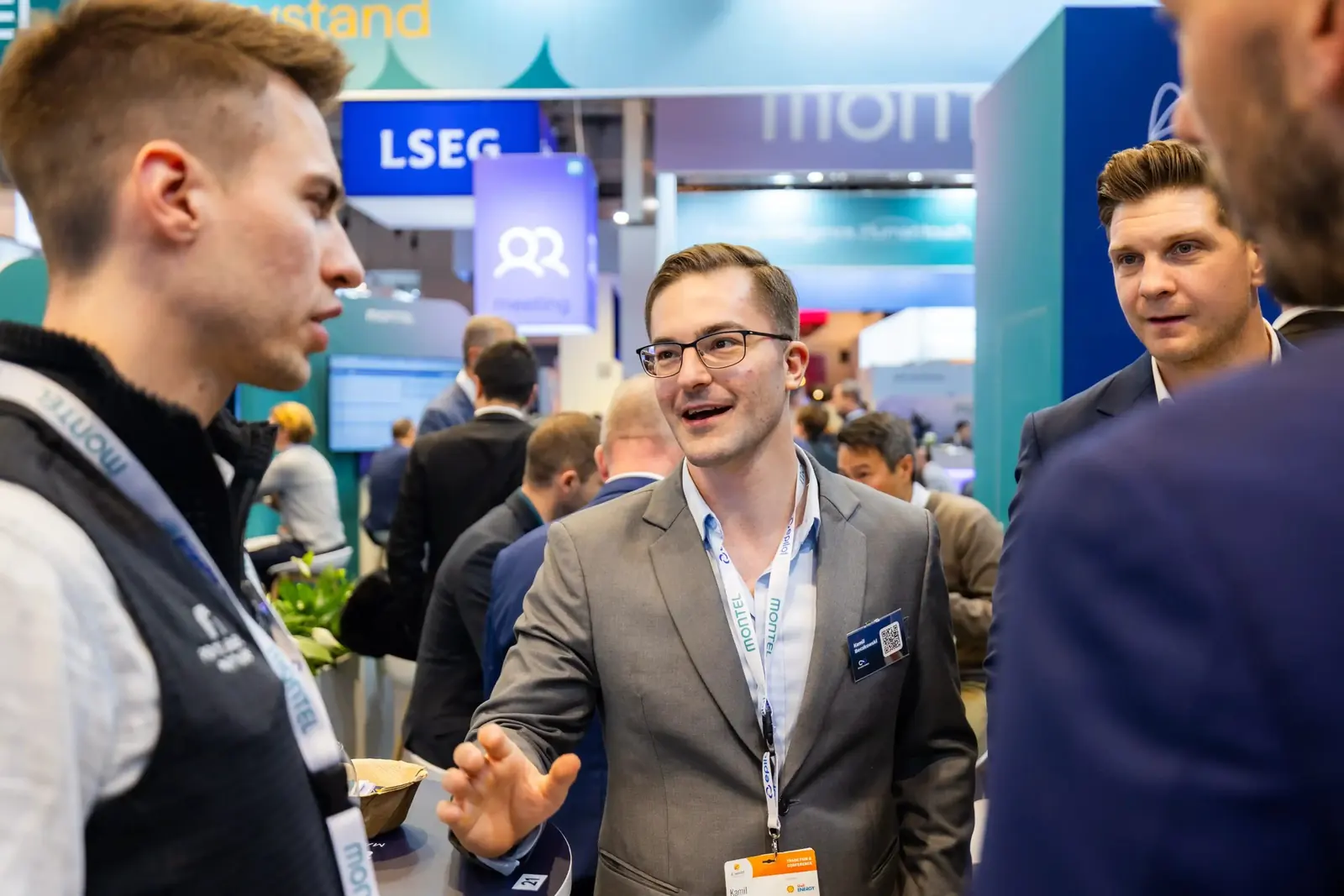 Besucher lacht im Gespräch am Stand von Time2Market