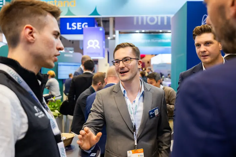Besucher lacht im Gespräch am Stand von Time2Market