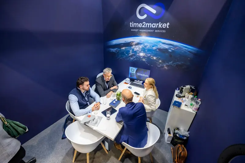 Blick von oben auf ein Meeting am Stand von Time2Market
